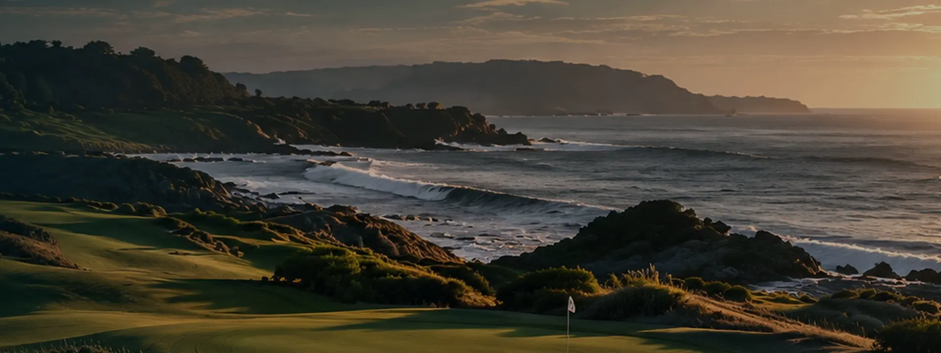 Coastal links at first light, fairway and dunes in the foreground and the Atlantic running out to a low headland.